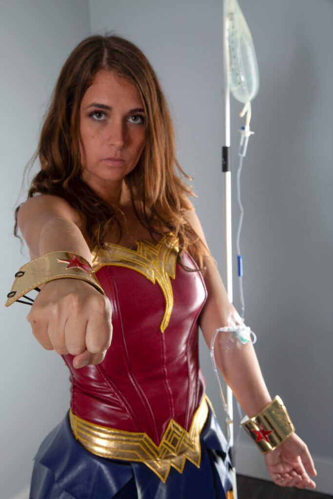 Sarah in as Wonder Woman punching forward