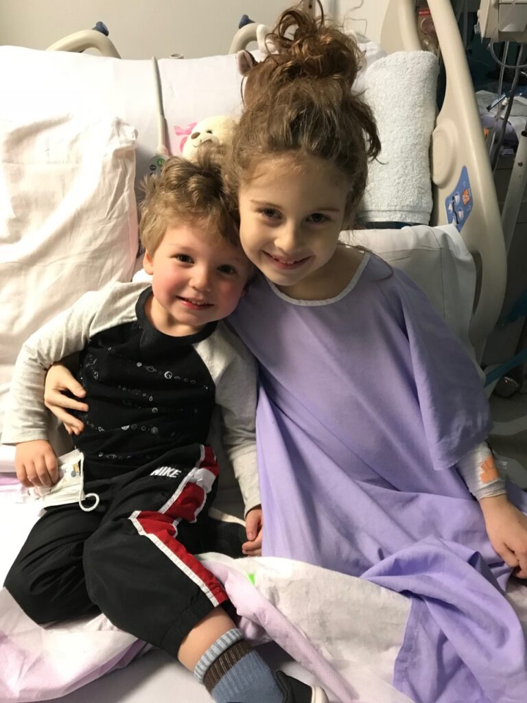 Sophia and her brother in the hospital bed smiling