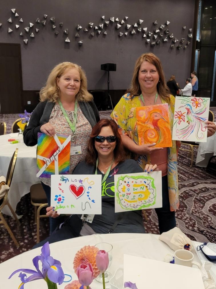 Dana Yates, Julia Lefelar and Andrea Mitchell show off their art work after Artistry iNMOtion on Patient Data 2022