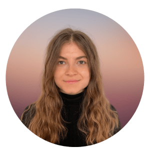 Yana Said is shown smiling. She has brown hair and is wearing a black turtleneck sweater.