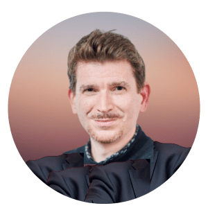 Romain Marignier is shown wearing a black shirt. He is smiling and has brown hair and a mustache.