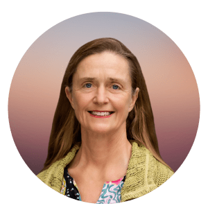 Dr. Emmanuelle Waubant is shown smiling. She has light skin, brown hair and is wearing a multi-colored flowered top covered by a chartreuse sweater.