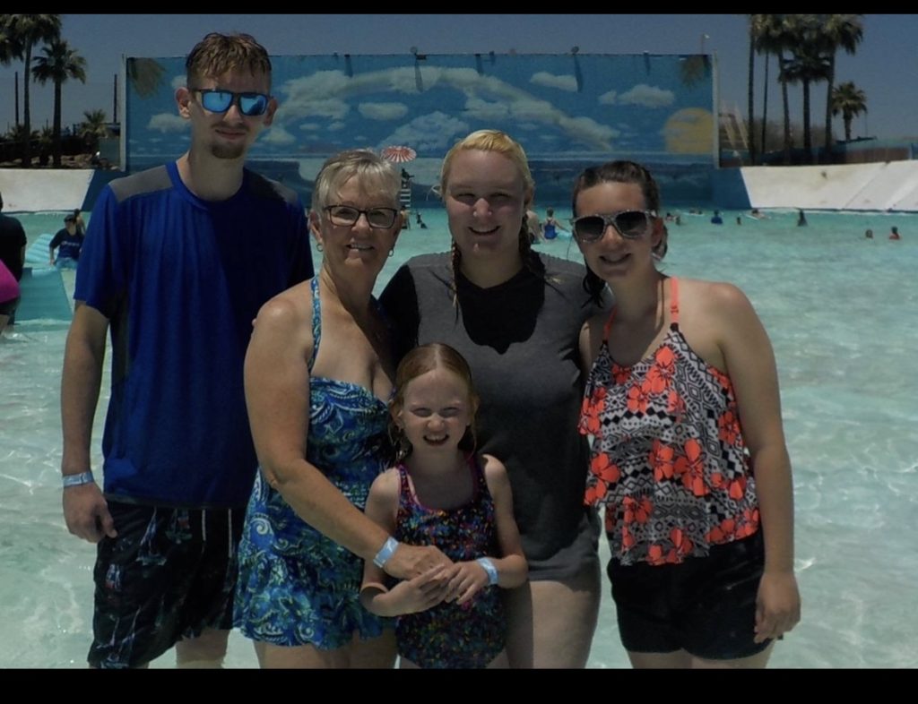 Alexandra is standing in front of a wave pool with her family.