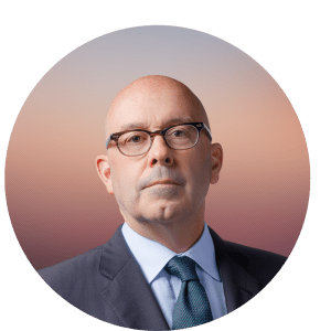 Kevin O'Connor, PhD is shown wearing a suite and tie with a white shirt. He has dark glasses light skin and no hair.