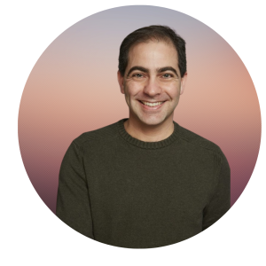 Dr. Levy with short dark hair wearing a dark green sweater, posed in front of a circular background with a soft pink and purple gradient.