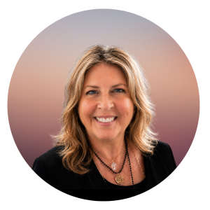 Julia Lefelar is shown. She has wavy, blonde hair smiles at the camera. She wears a black top and layered necklaces, set against a gradient background with soft colors—capturing the warmth and welcoming spirit at the heart of About The MOG Project.