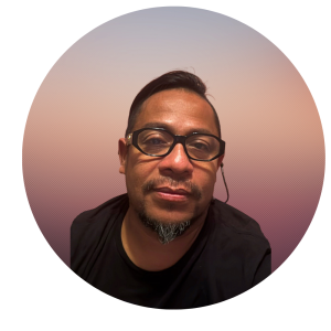 A person with short dark hair, glasses, and a short beard wearing a black shirt sits in front of a gradient background fading from pink to purple, ready to share insights about The MOG Project.